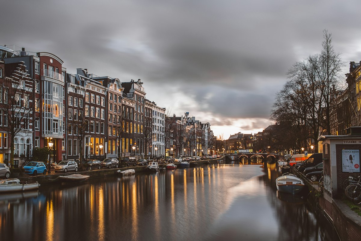 Canal houses along the water in Amsterdam, Netherlands at dusk